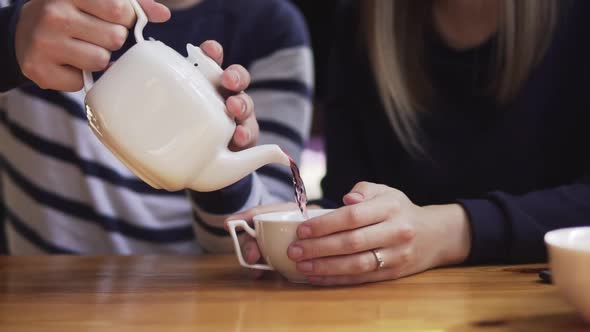 Closeup View of Man's Hand Pouring Tea Into a Cup