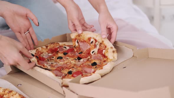 A Close-up To Female Hands Taking a Piece of Delivery Pizza