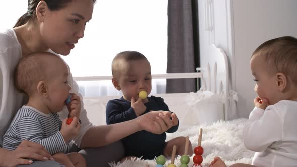 Asian Woman Removing Toy from Baby’s Mouth