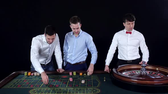 Young Man Playing Roulette in the Casino. Dealer Takes Bets. Black