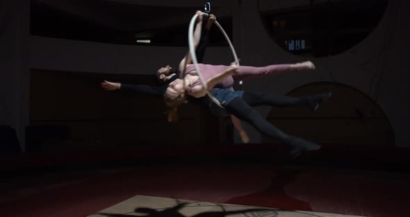 Flexible Woman and Man Are Posing in a Hoop in the Air Gymnastics