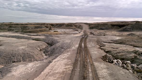 Flying over muddy dirt road partially washed out from flash flooding