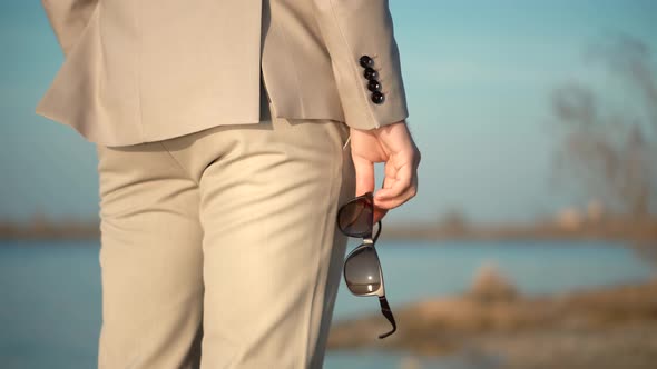 Man With Sunglasses In Hand.Businessman Hand Holding Pair Of Polarized Sunglasses.