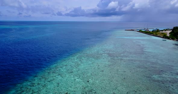 Natural flying travel shot of a summer white paradise sand beach and turquoise sea background in vib