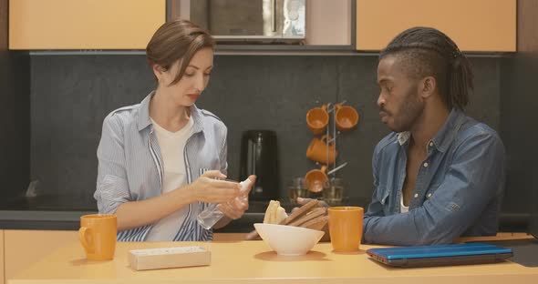 Portrait of Young Interracial Couple Disinfecting Hands Before Meal in Kitchen. African American Man