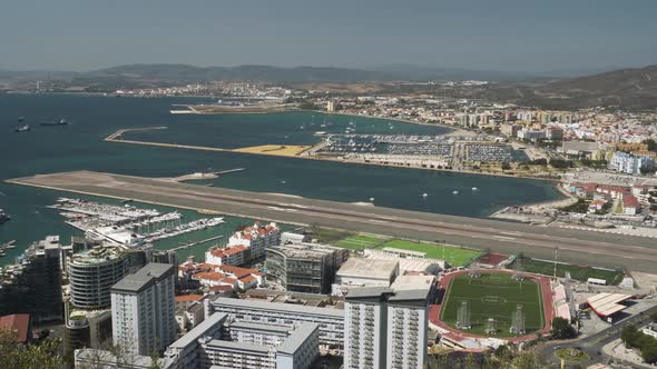 Bay of Gibraltar city harbor and airport runway stretching to sea.