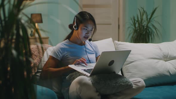 Asian Woman Using Laptop in Living Room