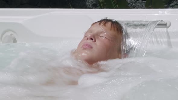 A boy relaxing in a jacuzzi