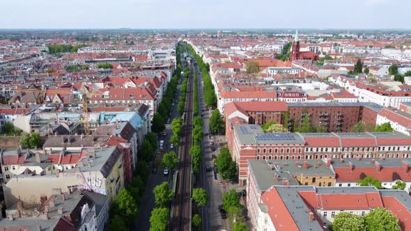 Panorama elevated railroad track trees houses in street. Fantastic aerial view flight slowly tilt do