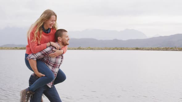 Caucasian couple having a good time on a trip to the mountains, smiling, the man holding the woman