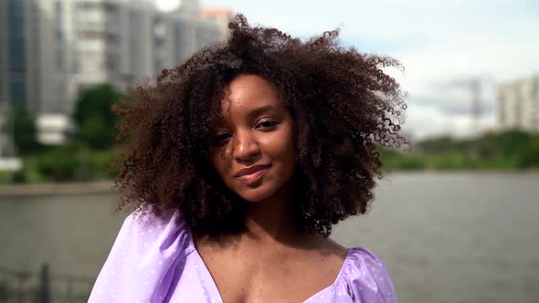 Young Sexual Afro American Woman Is Looking at Camera at City Background at Summer Day