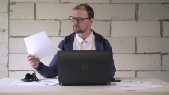 Businessman working in office with laptop and business charts