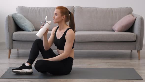 Sporty Lady Drinking Water From Bottle During Workout Indoor SideView