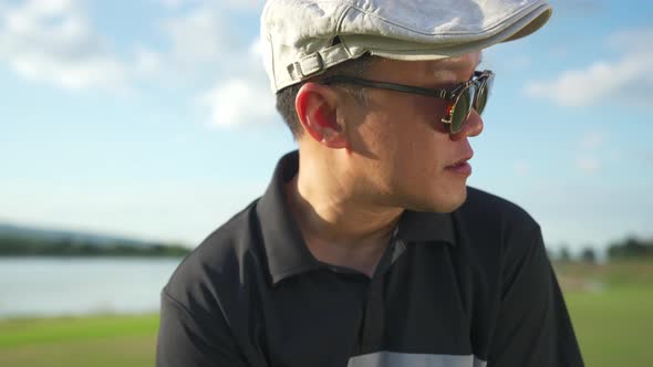 4K Portrait of Asian man golfer golfing on golf course at country club at summer sunny day.