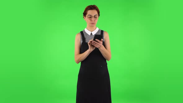 Funny Girl in Round Glasses Is Texting on Her Phone, Green Screen