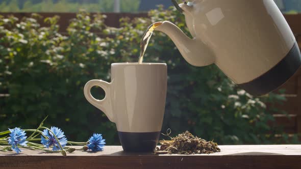 Tea pouring into a cup from teapot
