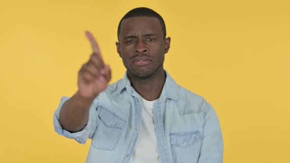 Young African Man No Sign By Finger Yellow Background