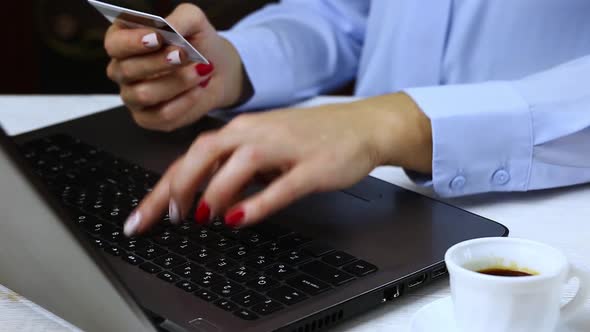 Woman Typing Credit Card Data on Laptop Computer.