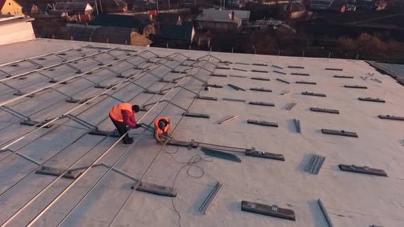 Installing solar panels on roof. Workers with solar panels construction on the roof