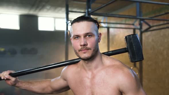 Confident Fit Man with Hammer in the Gym.