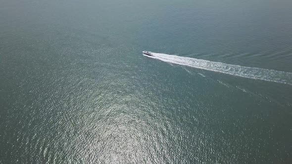 Drone footage of a watercraft underway traveling across the vast ocean.