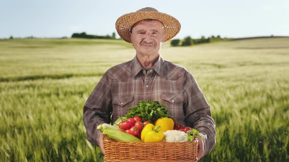 An Old Smiling Farmer is Standing in the Middle of a Field