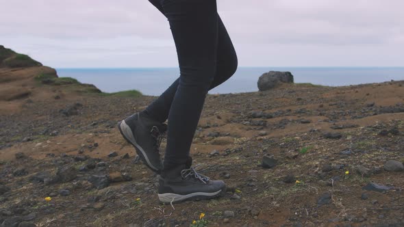 Back View of Young Attractive Girl Walking Outdoors on Background of Mountain Landscape and Ocean