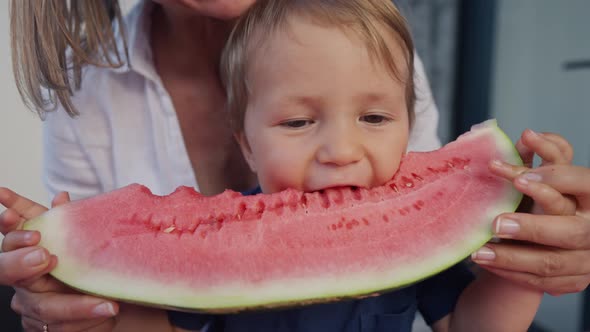 Young Mom with Daughter Eat Watermelon at Home