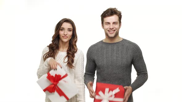 Young Couple Showing and Giving Present To Camera on White Isolated Background