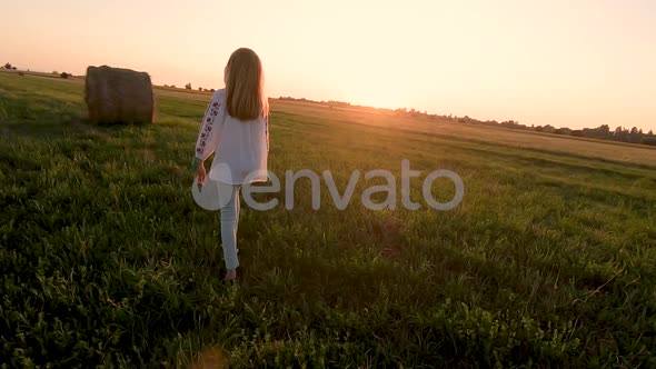 Girl Running In Harvested Wheat Field