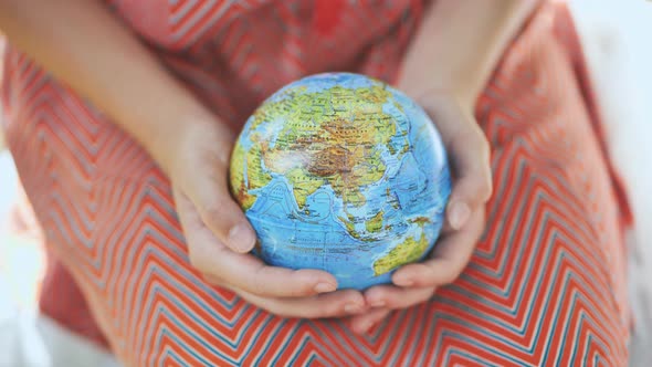 The Little One is Holding a Geographic Globe