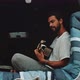 Young man sitting in the back of a van playing the guitar and singing - VideoHive Item for Sale