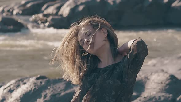 Sensual Girl Poses at Riverbank on Windy Day Slow Motion