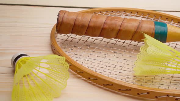 Badminton Rackets and Shuttlecock on Wooden Background Close Up