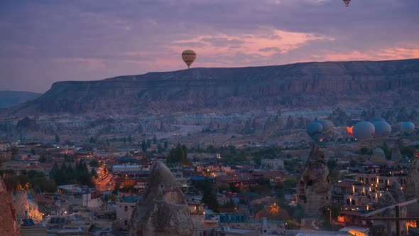 Colorful Hot Air Balloons Take Off Over Rock Landscape at Night Goreme Cappadocia Turkey