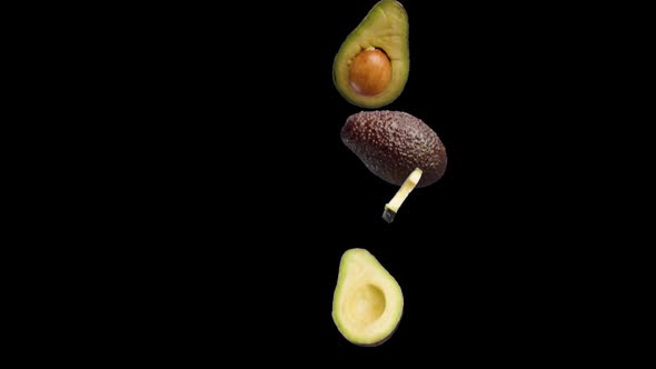 Avocado Halves and Slices That Fall on a Black Background