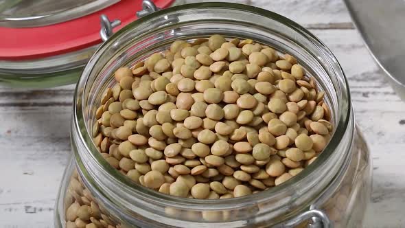 Dried green lentils in a glass jar close up full frame 