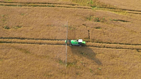 Aerial Farming Tractor Spraying On Field With Sprayer Herbicides And Pesticides