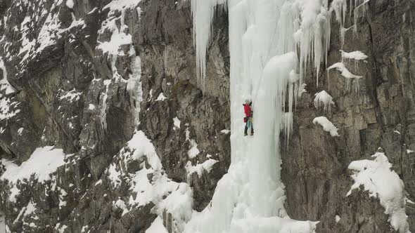 Amazing aerial lone climber scaling ice cascade Maineline, Mount Kineo 4K