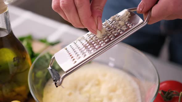 Making Caesar Salad Sauce  Woman Adding Grated Garlic Into Glass Bowl