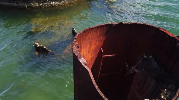 Close-up panning shot of the ruined smoke stack from the sunken World War II battleship USS Arizona