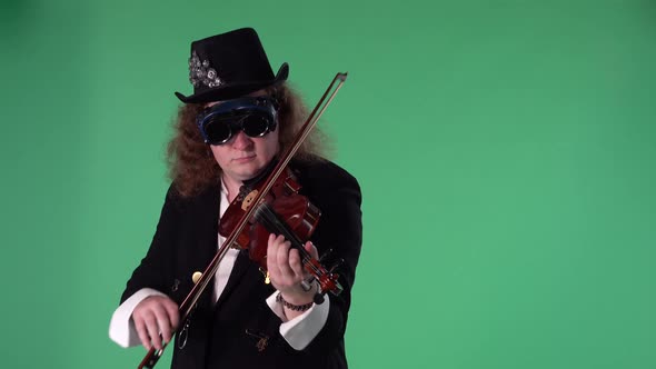 A Violinist in a Black Suit Hat and Original Glasses Plays the Violin Masterly