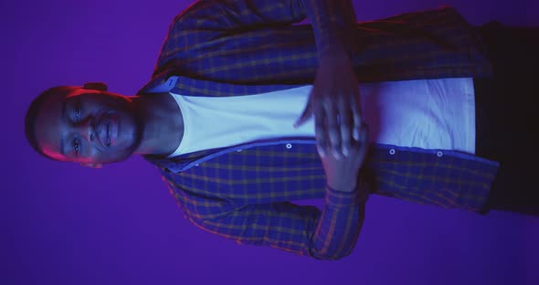 Young African American Man Dancing in Neon Lights Background Having Fun Video for Vertical Story