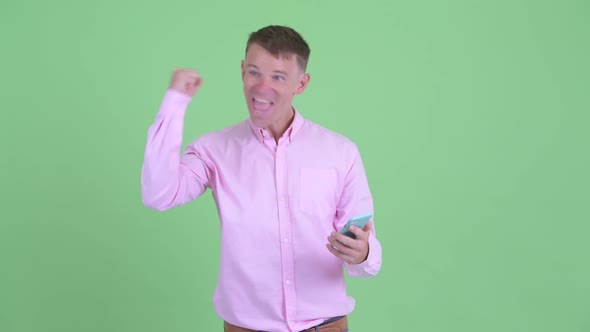 Happy Businessman Using Phone and Getting Good News