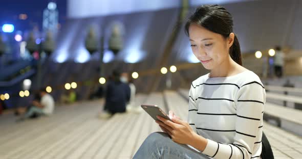 Woman looking at mobile phone at night 