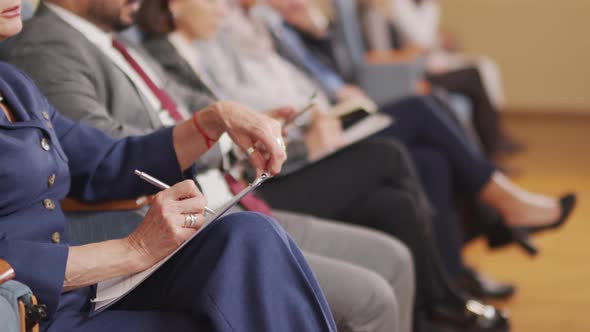 Woman Taking Notes at Political Forum