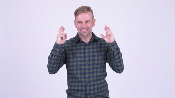 Portrait of Happy Blonde Hipster Man Wishing with Fingers Crossed