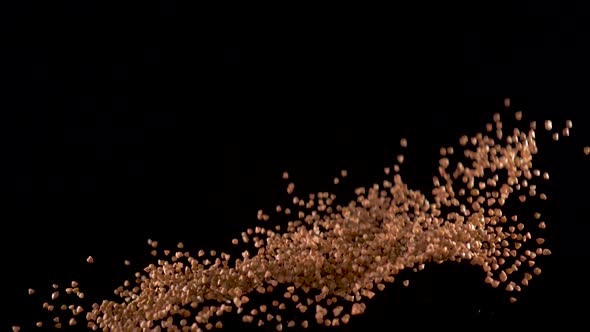 Buckwheat Flies Up and Falls Down on a Black Background. Slow Motion. Food Video