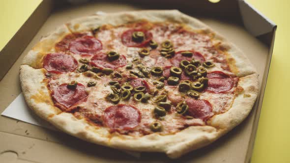 Pizza in a Cardboard Box Yellow Background