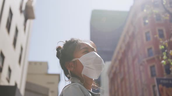 Mixed race woman wearing medical coronavirus mask on the street